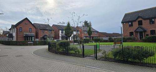a group of houses with a fence and a driveway at En-suite House, Minimum 3 nights bookings in Stockport