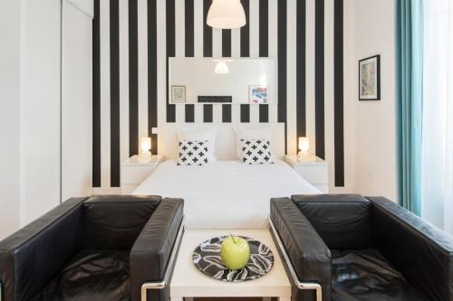 une chambre avec un lit à rayures noires et blanches dans l'établissement Le Studio Graphite Welkeys, à Nice