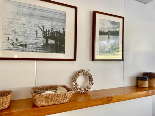 a shelf with two framed pictures and a wicker basket at Halcyon Days in St Helens