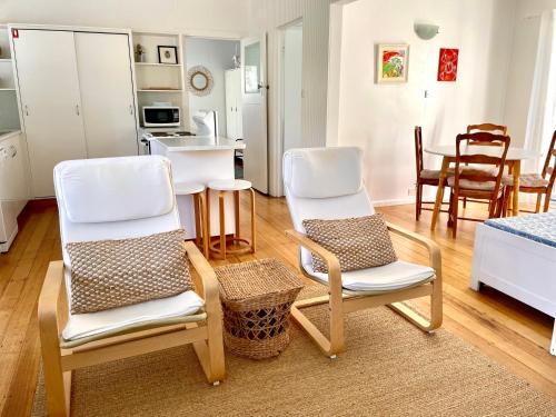a living room with two chairs and a kitchen at Halcyon Days in St Helens