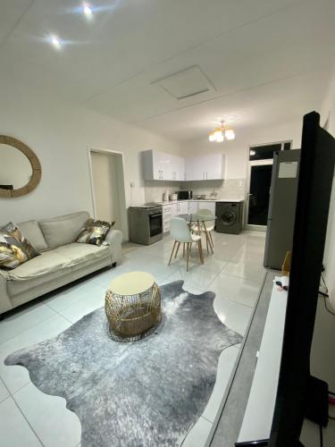 a living room with a couch and a table at Zahara Cousy Home in Windhoek