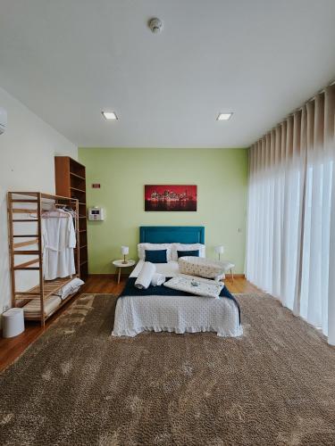 a bedroom with a bed with a blue headboard at Junção - Apartamentos Completos in Miranda do Douro