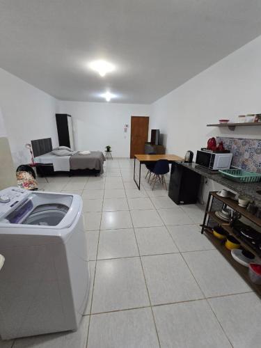 a large room with a kitchen and a living room at Estúdio Charmoso no Centro de Apiaí in Apiaí
