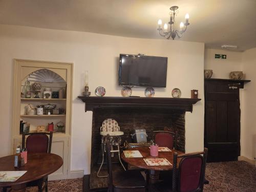 a living room with a fireplace with a tv above it at Langley Inn in Bristol