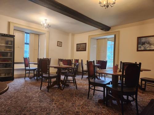 a dining room with tables and chairs and windows at Langley Inn in Bristol