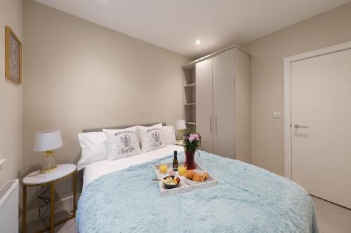 a bedroom with a bed with a tray of food on it at Dream Stays Bath - John Street Apartments in Bath