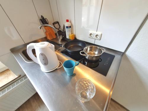 a small kitchen with a sink and a stove at Aparthotel B & L in Bremen