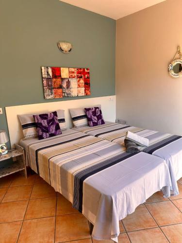 two beds in a room with purple pillows at Apartamento tosca mar con balcon 421 in Moraira