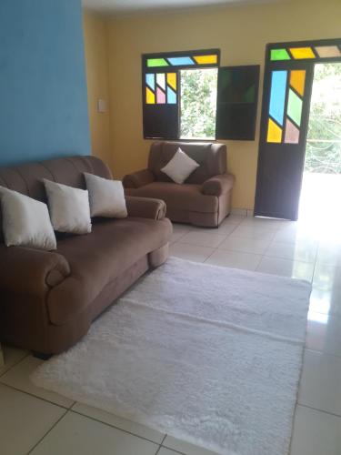 a living room with two couches and stained glass windows at Casa do Ed in Lençóis