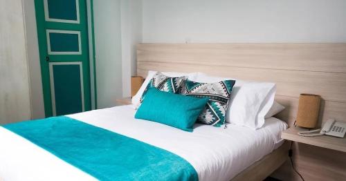 a bed with blue and white pillows on it at Hotel All In One in Armenia