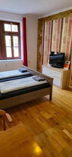 a room with two beds and a flat screen tv at Gwuni Mopera in Leipzig