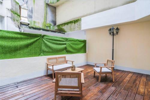 d'un balcon avec des chaises, une table et un mur vert. dans l'établissement Studio avec terrasse #SacréCœur #Montmartre - II, à Paris