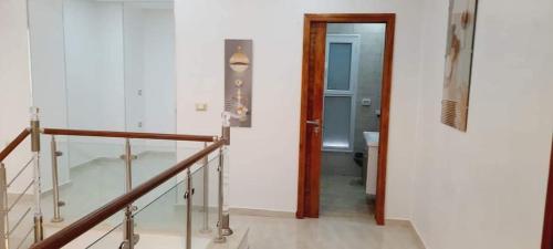a hallway with a stair case and a stair railing at Villa midoun in Taguermess