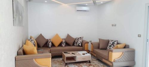 a living room with a couch and a table at Villa midoun in Taguermess