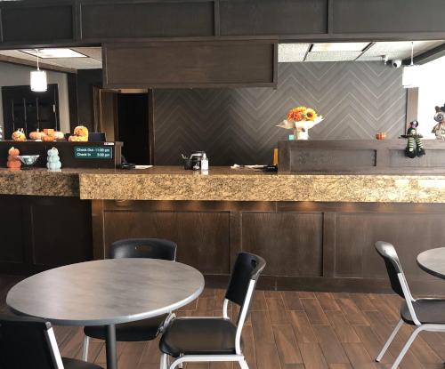a kitchen with two tables and chairs and a counter at Lamplighter Inn-South in Springfield