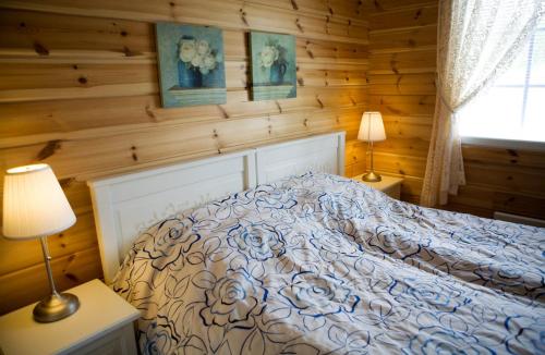 a bedroom with a bed in a wooden wall at Salkolahti Lomamökit in Längelmäki