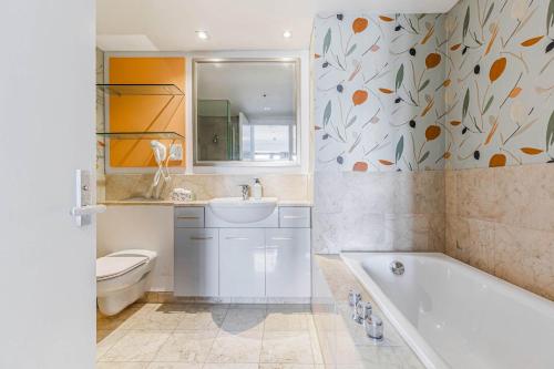 a bathroom with a tub and a toilet and a sink at Boutique Apt in the Heart of Auckland Zodiak Stays in Auckland