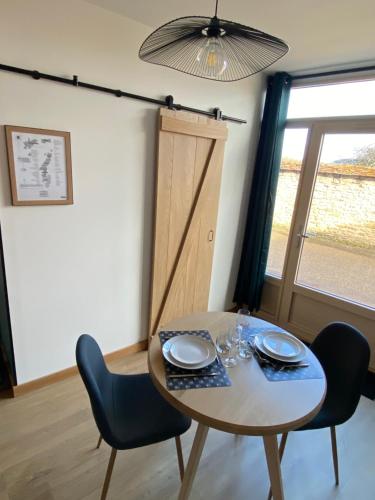 une table à manger avec deux chaises, une table et une fenêtre dans l'établissement Au studio cosy, à Chorey-lès-Beaune