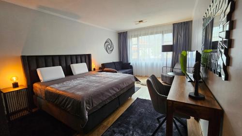 Un dormitorio con una cama y un escritorio con una computadora. en MONTEVERDE Tamplier, en Bansko