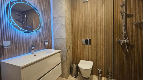 Un baño con lavabo, inodoro y espejo. en MONTEVERDE Tamplier, en Bansko