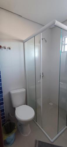 a bathroom with a toilet and a glass shower at Loft 02 in Bombinhas