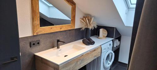 a bathroom with a sink and a washing machine at Ferienwohnung Haus Kampen in Aschau im Chiemgau