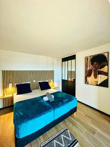 a bedroom with a large bed with a blue blanket at Sweety blue, vue mer in Les Trois-Îlets