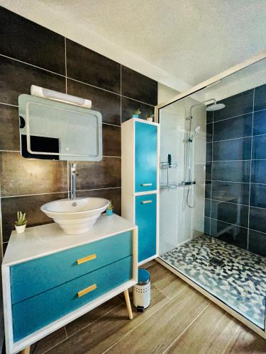 a bathroom with a blue sink and a shower at Sweety blue, vue mer in Les Trois-Îlets