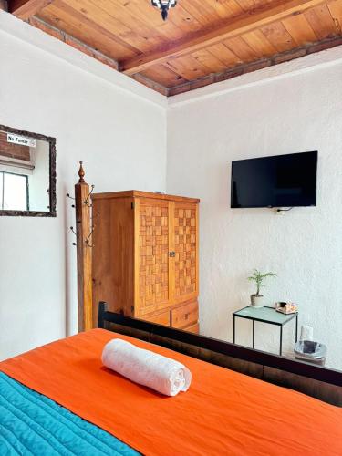 a bedroom with a bed and a flat screen tv at Hotel Boutique Casa Miranda in Querétaro