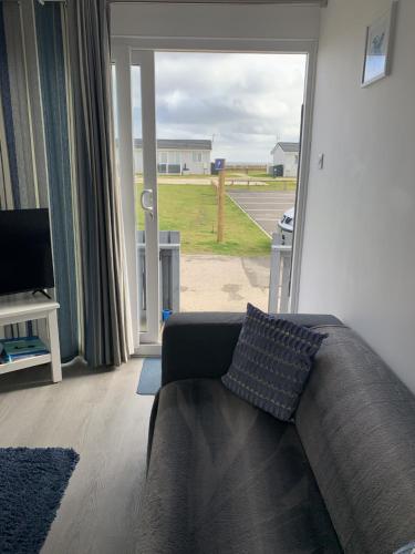 a living room with a couch and a large window at Isla's Haven Holiday Chalet in Bridlington