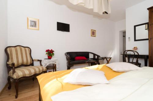 a bedroom with two beds and a chair at B&B Villa Dubrovnik Garden in Dubrovnik