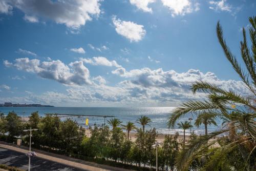 a view of a beach with palm trees and the ocean at Mediterranean Loft in Alicante
