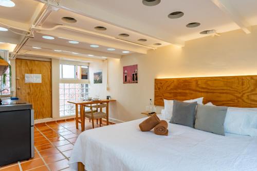 a bedroom with a large white bed and a table at Casa Jicama in Cancún
