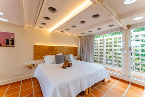 a bedroom with a large bed with white sheets at Casa Jicama in Cancún