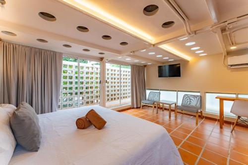 a bedroom with a white bed and a large window at Casa Jicama in Cancún