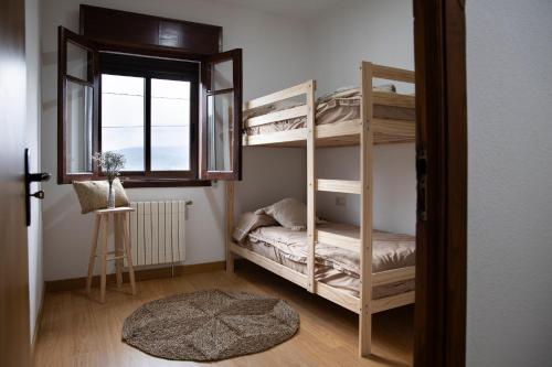 a bedroom with two bunk beds and a window at Villa Laudina in Vilaboa