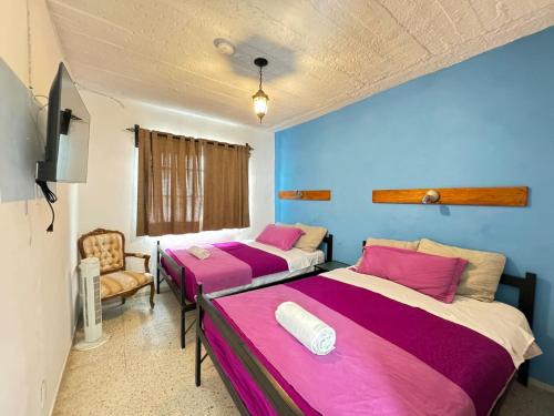 a room with two beds and a chair in it at Hotel Boutique Casa Miranda in Querétaro