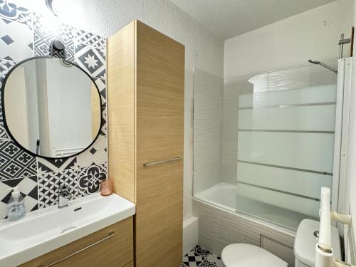 une salle de bain avec un lavabo et un miroir et des toilettes dans l'établissement Pied-à-terre au centre de Cauterets. 4 personnes., à Cauterets