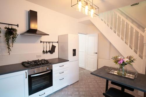 a kitchen with white cabinets and a stove at Moonlight Residence - Anfield Stadium, Free Parking & Free WiFi in Liverpool