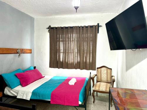 a bedroom with a bed and a flat screen tv at Hotel Boutique Casa Miranda in Querétaro
