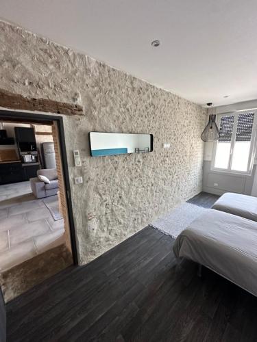 a bedroom with a bed and a stone wall at Gite Bildstein in Coullons