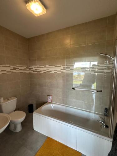 a bathroom with a tub and a toilet and a sink at Luxury 3 bed property overlooking River Erne Marina in Belturbet