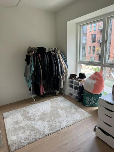 a room with a rack of clothes and a window at Flot Moderne Lejlighed byder Velkommen in Glostrup