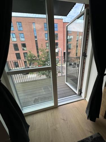 an open door to a balcony with a view of a building at Flot Moderne Lejlighed byder Velkommen in Glostrup