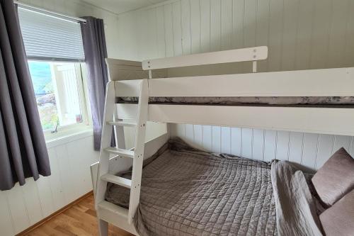 Norhern lights Luxus home -5 min AirPort-free park في ترومسو: سرير بطابقين أبيض في غرفة مع نافذة