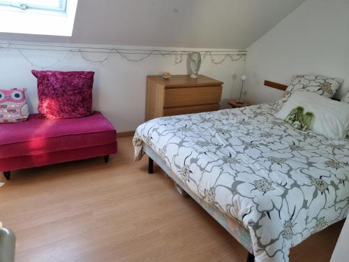 - une chambre avec un lit et un banc rose dans l'établissement Belle Maison d'Art Verdoyante & jardin, à Saint-Rémy-lès-Chevreuse