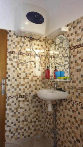 a bathroom with a sink and a mirror at Hotel Ain Leuh in Aïn Leuh