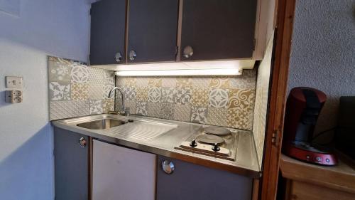 Il comprend une petite cuisine avec un évier et un comptoir. dans l'établissement Résidence La Taiga - Résidence TAIGA N°R2 MAE-1481, à La Plagne Tarentaise