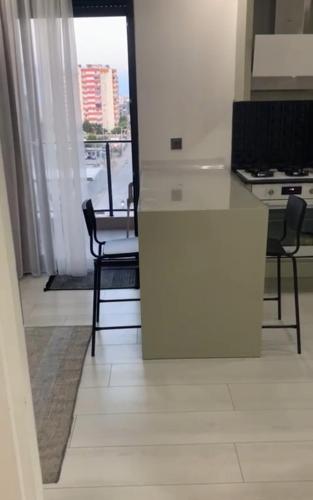 a kitchen with a white counter and a table and chairs at Lux Suite Room in YeÅŸilkÃ¶y