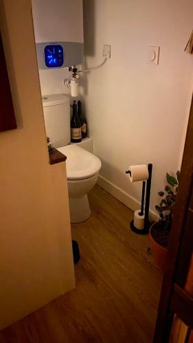 La salle de bains est pourvue de toilettes et d'une horloge murale. dans l'établissement Le repaire magique proche paris et Disney, à Fontenay-sous-Bois